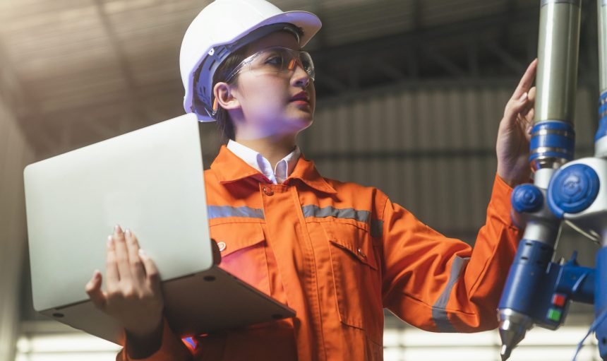 asian female engineer specialist with Measuring machine with a manipulator arm.Three-dimensional coordinate measurement. Check sizes. 3D check of the sizes of parts. CMM after machining process