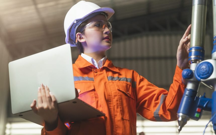 asian female engineer specialist with Measuring machine with a manipulator arm.Three-dimensional coordinate measurement. Check sizes. 3D check of the sizes of parts. CMM after machining process