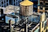 An amazing view of a downtown building roof with a water tank on it